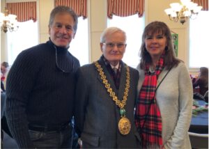 two men and a woman post for a photo. the man in the middle is a dignitary from Scotland and is wearing a gold medallion